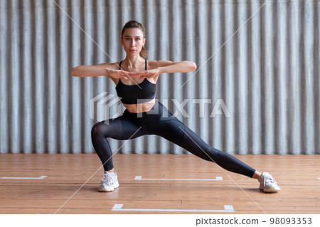 Fit woman doing stretching exercises. Full length. 98093353