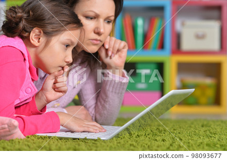 Mother with her little daughter using laptop 98093677