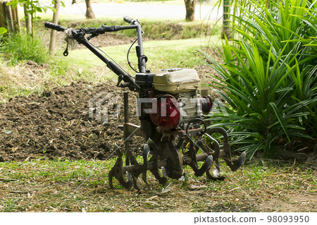 Rotary tiller helps to prepare the soil for modern farmers. 98093950