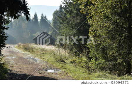 Forest and lodge increased from early morning autumn fog Forest and lodge increased from early morning autumn fog 98094271