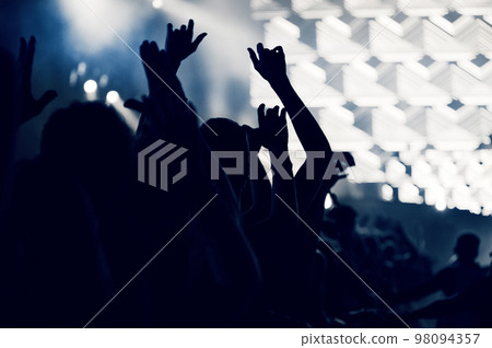 Crowd at a music concert, audience raising hands up, toned 98094357