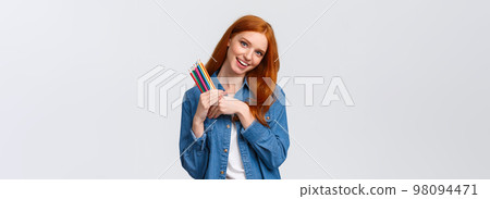 Creativity, imagination and people concept. Cheerful good-looking female college student painting, likes create artworks, holding colored pencils and smiling, tilting head dreamy, white background 98094471