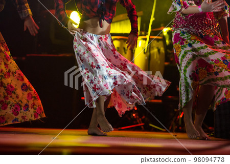 Young dancer woman barefoot in gypsy dress dancing on stage 98094778