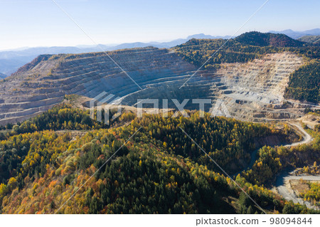 Flying above an open pit mine, copper excavation in Rosia Poieni, Romania. Aerial view 98094844