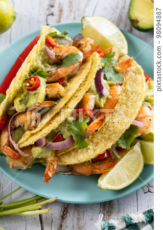 Mexican tacos with shrimp,guacamole and vegetables on wooden table 98094887