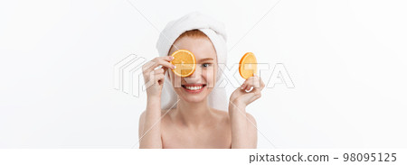 Great food for a healthy lifestyle. Beautiful young shirtless woman holding piece of orange standing against white background. 98095125