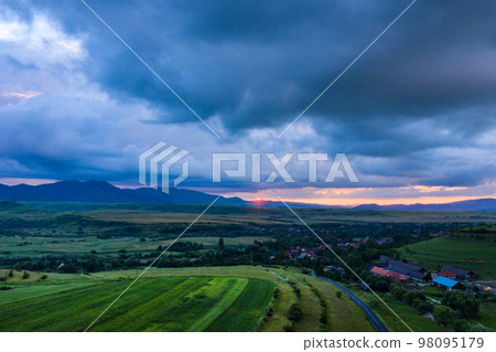 Aerial view of a storm and clouds above a village Aerial view of a storm and clouds above a village 98095179