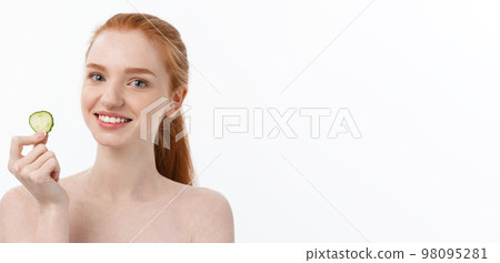 Close up beauty portrait of a smiling beautiful half naked woman holding cucumber slices at her face isolated over white background Close up beauty portrait of a smiling beautiful half naked woman holding cucumber slices at her face isolated over white background 98095281