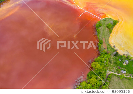 Aerial view of red waste water and green forest 98095396