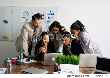 a team of developers is committed to a project while looking at a laptop monitor together a team of developers is committed to a project while looking at a laptop monitor together 98095484