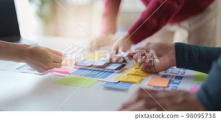 Group of UX UI or designers working to create content of mobile applications. Creative digital development agency concept Group of UX UI or designers working to create content of mobile applications. Creative digital development agency concept 98095738