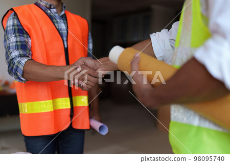 Architect and engineer construction workers shaking hands after finish an agreement in the office construction site, success collaboration concept Architect and engineer construction workers shaking hands after finish an agreement in the office construction site, success collaboration concept 98095740