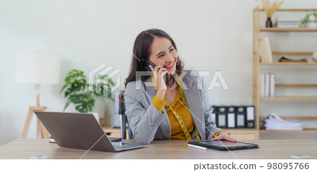 Asian Woman fashion designer cloth tailor creative working for new collection. Happy online store owner preparing an order for shipping. Asian Woman fashion designer cloth tailor creative working for new collection. Happy online store owner preparing an order for shipping. 98095766