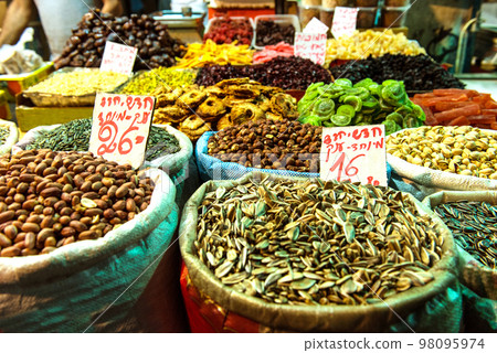 Heap of nuts and sunflower seeds, pistachio in bags Heap of nuts and sunflower seeds, pistachio in bags 98095974