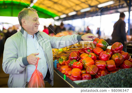 Man buying peppers in market Man buying peppers in market 98096347