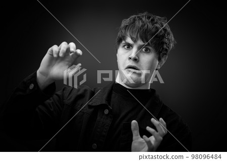 crazy young man with awesome hairdo grimacing 98096484