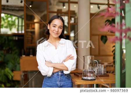 Portrait of smiling asian girl in white collar shirt, working in cafe, managing restaurant, looking confident and stylish 98097369