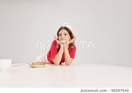 Portrait of young female waitress, sensual woman in retro american fashion style of 70s, 80s in action motion over grey background. Portrait of young female waitress, sensual woman in retro american fashion style of 70s, 80s in action motion over grey background. 98097640