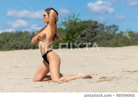 Sexual woman in bikini panties on beach 98099068