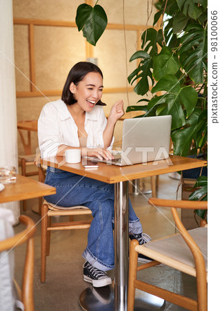 Excited asian girl found something online, looking at laptop screen with surprised, amazed face, sitting in cafe Excited asian girl found something online, looking at laptop screen with surprised, amazed face, sitting in cafe 98100066