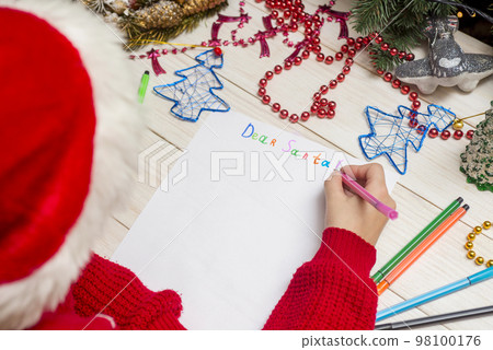 Little boy in Santa hat writes letter to Santa Claus 98100176