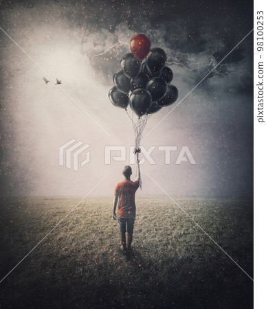 Bizarre scene of a lone person in the field holding a bunch of balloons in his hand in hope of starting flying. Conceptual and inspirational art 98100253