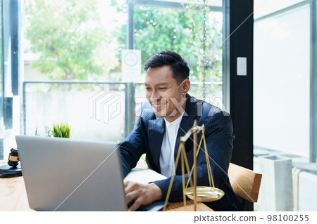 Portrait of a Asian man lawyer studying a lawsuit for a client before going to court. 98100255