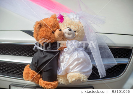 white and brown small decorative bears in wedding clothes to decorate the car of the bride and groom 98101066
