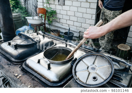 A man prepares lunch in a military field kitchen. 98101146