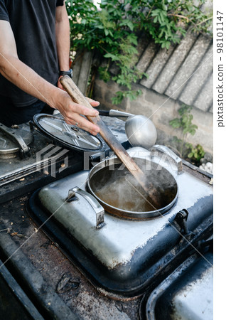 A man prepares lunch in a military field kitchen. 98101147