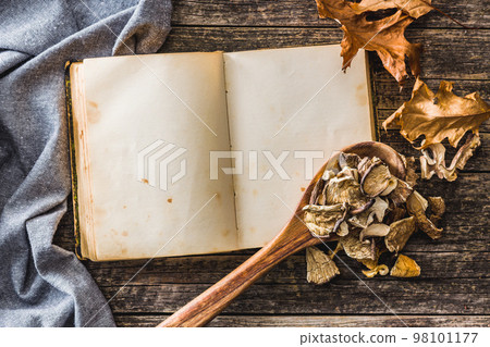 Blank recipe book and sliced dried mushrooms on wooden table. Top view. Blank recipe book and sliced dried mushrooms on wooden table. Top view. 98101177