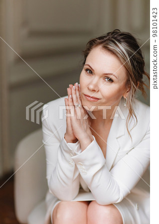 an attractive and gentle woman in a white suit. an attractive and gentle woman in a white suit. 98101423