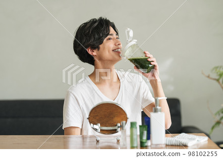 A man who drinks green juice for beauty 98102255