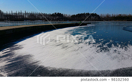 Various white snow and ice figures blooming on the snow-covered lake 98102560