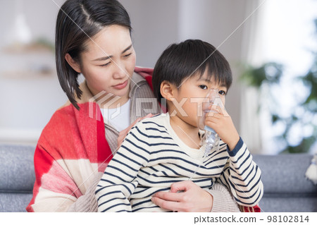 Boy inhaling asthma with a nebulizer 98102814