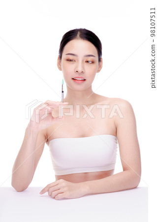 Female holding a syringe with an injection. Cosmetic procedures, Botulinum toxin injections, hyaluronic acid. Female holding a syringe with an injection. Cosmetic procedures, Botulinum toxin injections, hyaluronic acid. 98107511