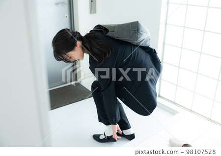 A woman in a suit at the entrance 98107528