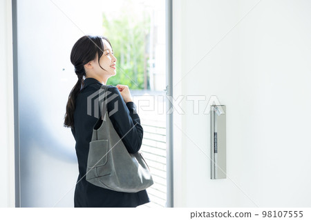 A woman in a suit at the entrance A woman in a suit at the entrance 98107555
