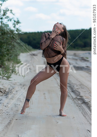 Sensual woman standing on seashore 98107933