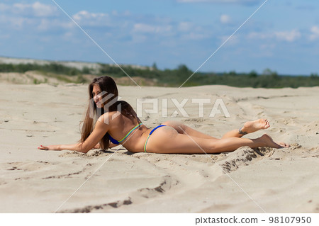 Slim woman resting on sandy beach 98107950