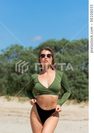 Attractive woman standing on seashore Attractive woman standing on seashore 98108035