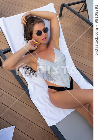 Sexy woman in swimwear lying on deckchair 98108293