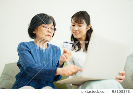 Daughter teaching mother online shopping Daughter teaching mother online shopping 98108378