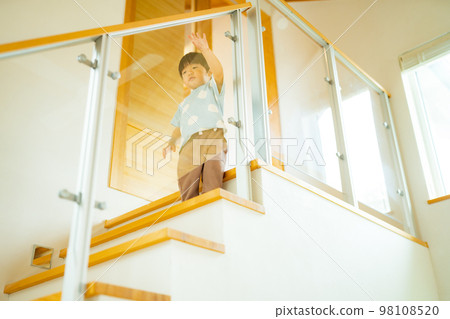 A 2-year-old boy walking down the stairs alone A 2-year-old boy walking down the stairs alone 98108520