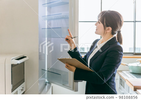 Business woman checking and inspecting the electricity and refrigerator in the kitchen 98108856