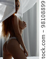 Sensual woman undressing on bed 98108899