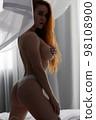 Sensual woman undressing on bed 98108900