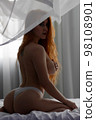 Sensual woman undressing on bed 98108901