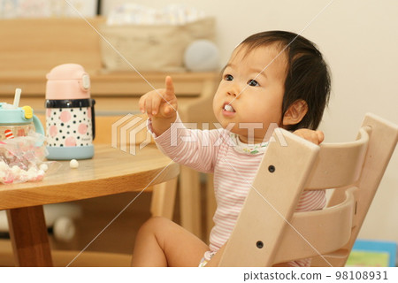 一個女孩的寶寶正在註意某事並用手指著手指│0至1歲的女孩/嬰兒 98108931