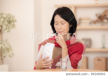 Poor physical condition Middle-aged woman taking medicine 98108942